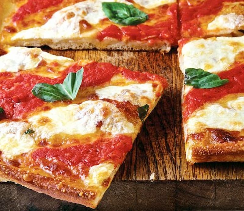 thin crust pizza topped with sauce, mozzarella cheese clumps and basil
